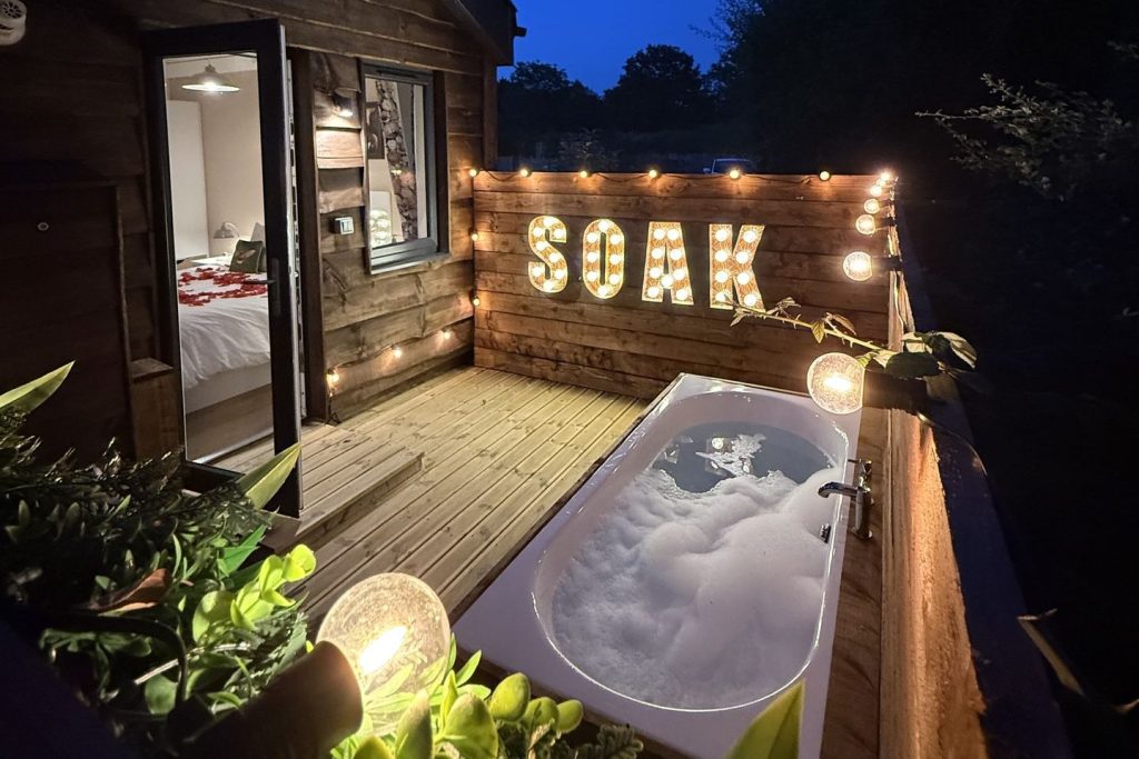 Montana Log Cabin outdoor bath and SOAK sign at night, Ockeridge Rural Retreats