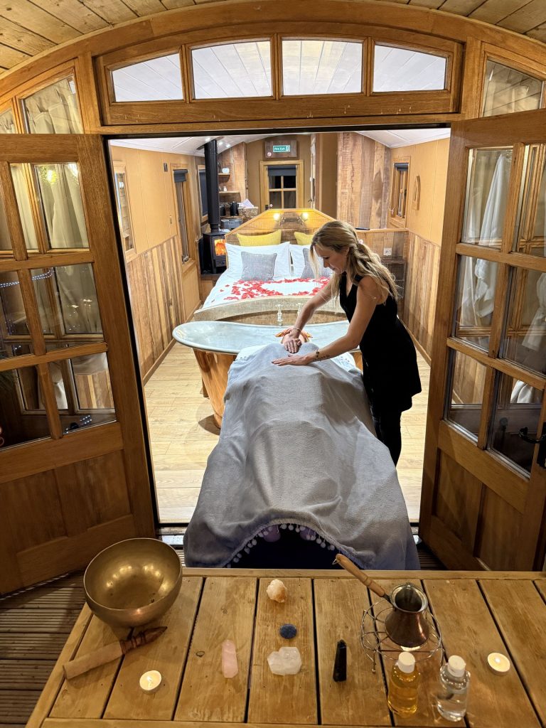 Holistic therapist preparing a massage couch inside a shepherd's hut, Ockeridge Rural Retreats, Worcestershire